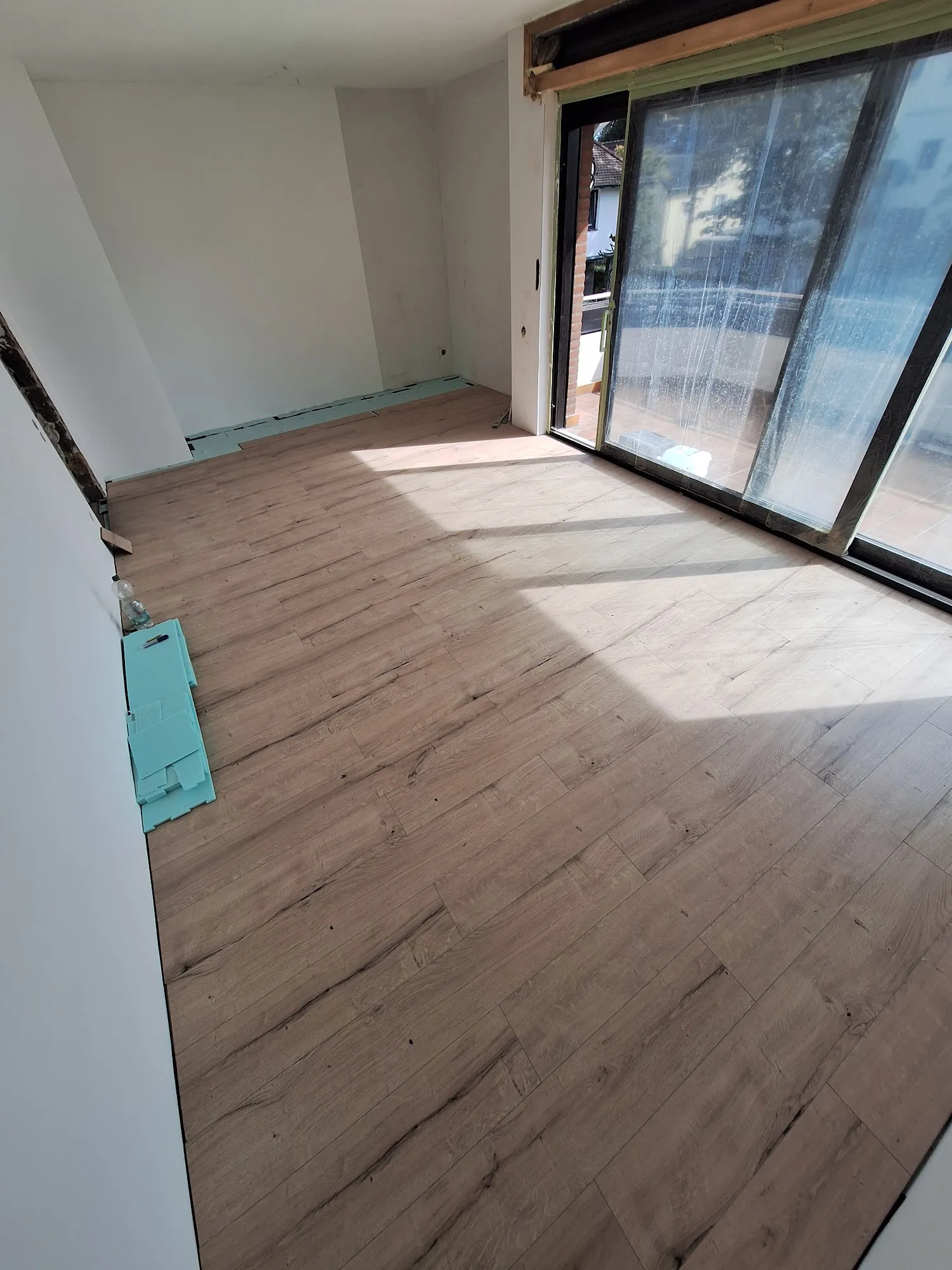 Renovierter Raum mit neu verlegtem Boden in Holzoptik